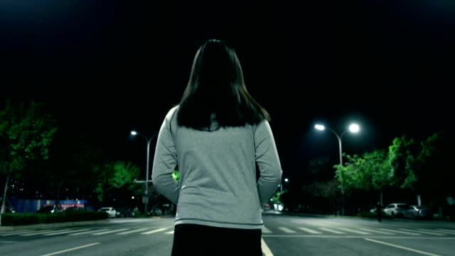 Woman walking alone at night street