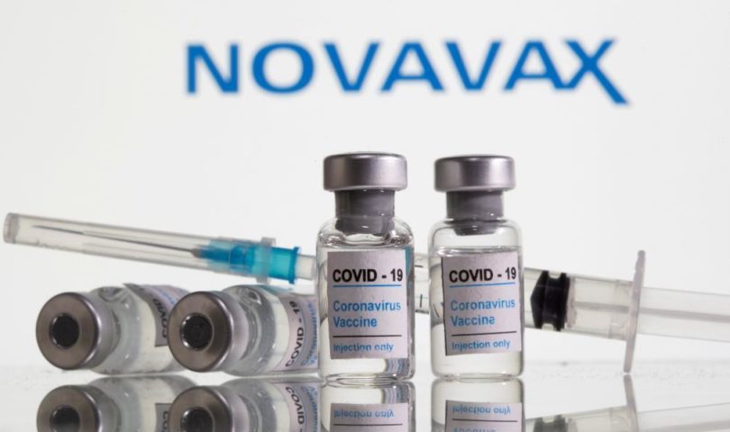 FILE PHOTO: Vials labelled "COVID-19 Coronavirus Vaccine" and syringe are seen in front of displayed Novavax logo in this illustration