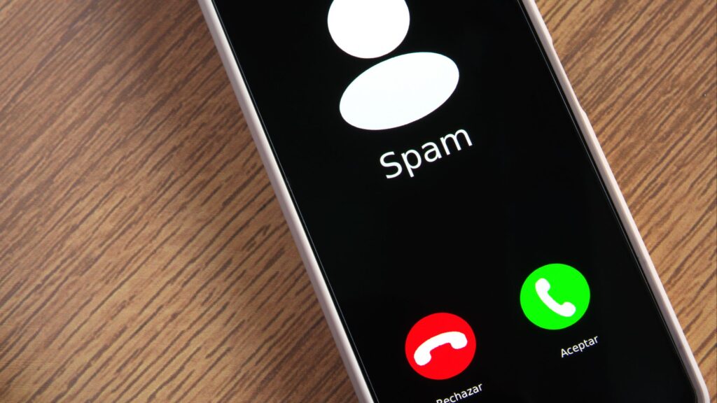 Incoming spam call on mobile phone on table
